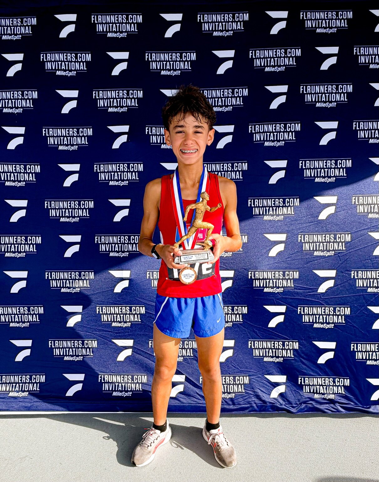 Enzo Maia segurando o troféu e celebrando seu novo recorde pessoal nos 3K XC